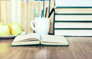 Stack of books, pencils, open book, glasses, background for education learning concept.
