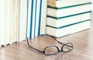 Stack of old book education concept background with glasses, many books piles with copy space for text.