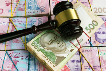 Bribes and corruption in Ukrainian court. Gavel on stacks of hryvnia.