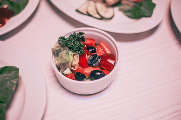 fresh vegetable salad in a white bowl on the dining table