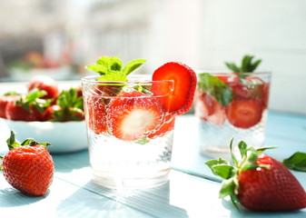 refreshing summer drinks detox water with fresh strawberries  and mint on blue wooden surface, table, background. Copy space