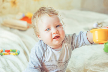 Fototapeta premium The child plays on the bed