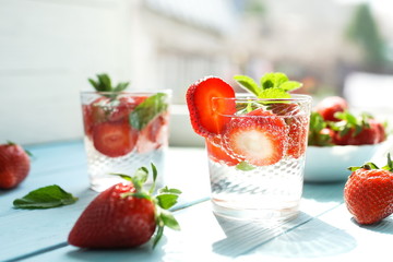 refreshing summer drinks with fresh strawberries  and mint on blue wooden surface, table, background. Copy space