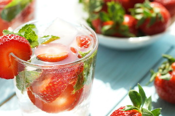 refreshing summer drinks with fresh strawberries  and mint on blue wooden surface, table, background. Copy space