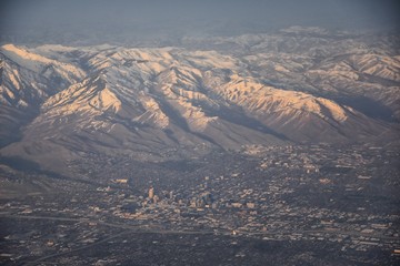 Aerial view from airplane of the Wasatch Front Rocky Mountain Range with snow capped peaks in winter including urban cities of Provo, Farmington Bountiful, Orem and Salt Lake City. Utah. United States