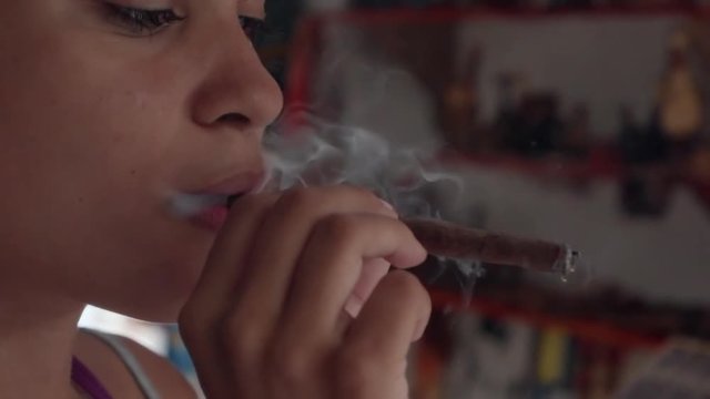 Slow Motion: Close-Up of Beautiful Young Woman Exhaling Cigarillo Smoke in El Limon, Dominican Republic