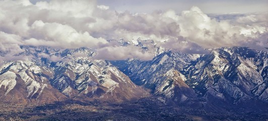 Aerial view from airplane of the Wasatch Front Rocky Mountain Range with snow capped peaks in winter including urban cities of Provo, Farmington Bountiful, Orem and Salt Lake City. Utah. United States