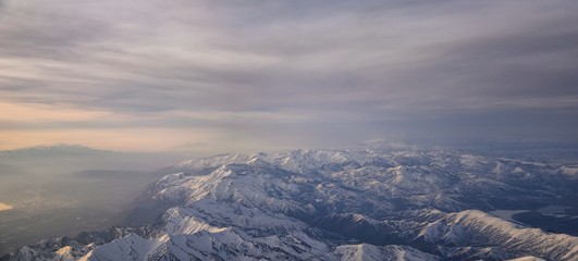 Aerial view from airplane of the Wasatch Front Rocky Mountain Range with snow capped peaks in winter including urban cities of Provo, Farmington Bountiful, Orem and Salt Lake City. Utah. United States