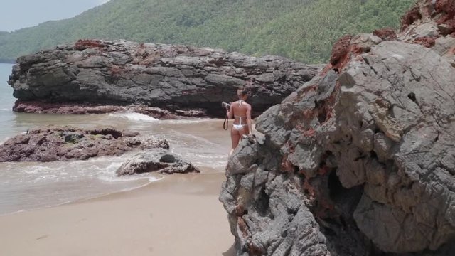 Slow Motion: Young Woman in Bikini Walking Among Rocks on Sandy Shore in El Limon, Dominican Republic