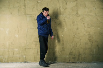 A disheveled man with alcohol in his hand.