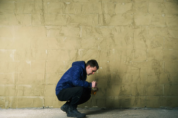 A disheveled man with alcohol in his hand.