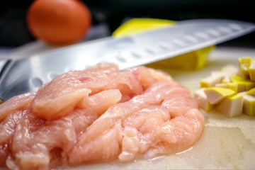 Food Preparation with Sliced Raw Chicken on a Cutting Board