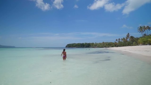 Slow Motion: Young Woman in Bikini Waving and Wading Knee-Deep in Tropical Ocean in El Limon, Dominican Republic