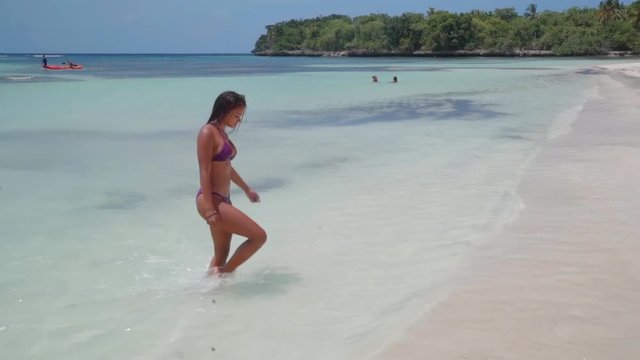 Slow Motion: Beautiful Young Woman in Bikini Walking Out of Clear Tropical Ocean in El Limon, Dominican Republic