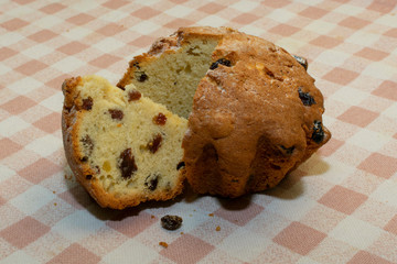 a small cake with raisins cut into pieces, lying on a checkered tablecloth table