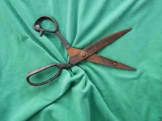 scissors on green fabric background