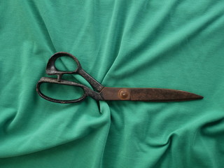 scissors on green fabric background