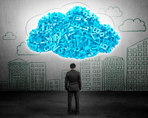Big data and cloud computing concept. Rear view of businessman facing huge cloud of blue letters and numbers, with cityscapes doodles of concrete wall background.