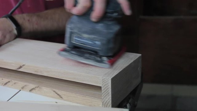 Finish Sanding The Wood Filler On Wooden Floating Shelves In Preparation To Be Stained And Hung In A Remodeled Bathroom.