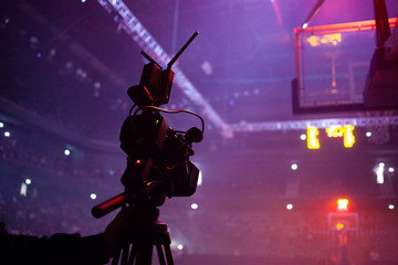professional camera filming basketball game live in sports arena