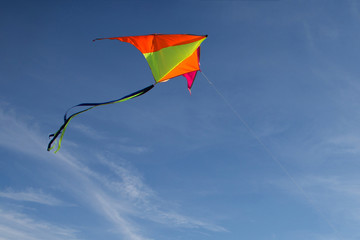 Flying a kite. Bright kite against the blue sky. Sunny day.
