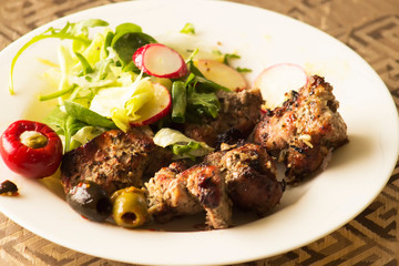 Freshly made shashlik in a plate with vegetable prawn. Traditional Russian pork dish