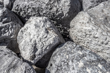 Huge gray boulders lie on the beach.