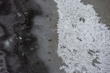 The surface of the river covered with ice and snow with prints of bird legs