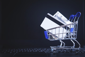 Shopping cart and credit card on laptop keyboard. © andranik123