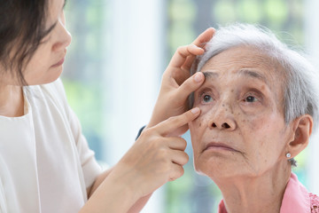 Doctor checking senior woman patient eyes,Ophthalmologist examining eyes of asian elderly woman in...