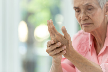 Asian old woman is massaging her own hand,Elderly woman suffering from pain in...