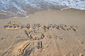 Summer word is written on the beach sand