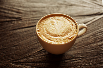 Cup of cappuccino on wooden background