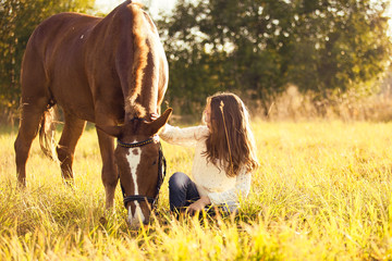 Young girl with horse in field
