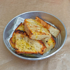 sliced bread roasted with vorgin olive oil and oregano in metalic dish