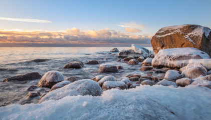 Scenic winter landscape with sea and sunrise at morning. Beautiful light with rocky coast in Finland.