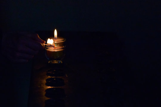 Lighting A Votive Candle In Church