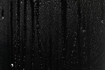 Obraz na płótnie Canvas black wet background / raindrops for overlaying on window, concept of autumn weather, background of drops of water rain on glass transparent
