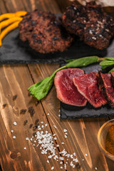fried meat sliced, burgers and stakes. on a wooden table