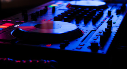 DJ controller live show at night club dance music in neon light