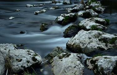 steine bilden einen weg über den dunklen fluss
