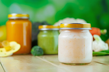 Cauliflower puree in glass jar on the wooden background