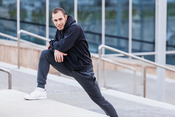 Portrait of a positive young male athlete coach doing morning workout outside in scenic spots. Concept of preparation for competitions and a healthy lifestyle