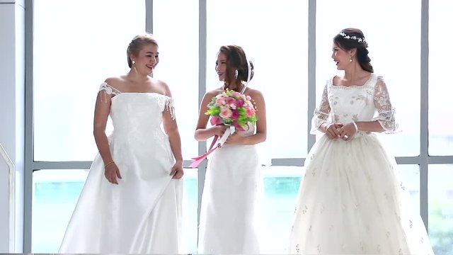 Slow motion scene video of group of brides walking forward, they talking and tittering together.