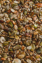 close up of pumpkin and sunflower seeds roasted in black pan, top view