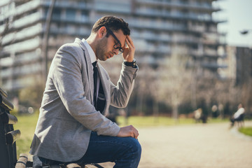 Young businessman is having headache. 