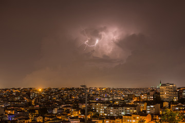 Lightning storm over city in purple light