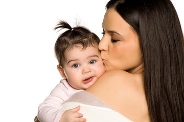 A happy young mom kisses her baby daughter on a white background
