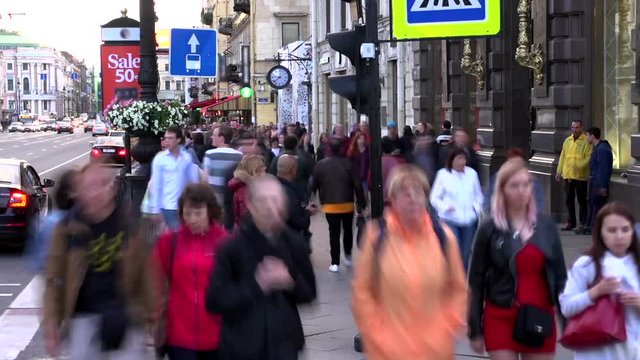 Pedestrian Traffic at Rush Hour. Time Lapse. Active Streams of people and cars in an urban environment. Slowly evening comes