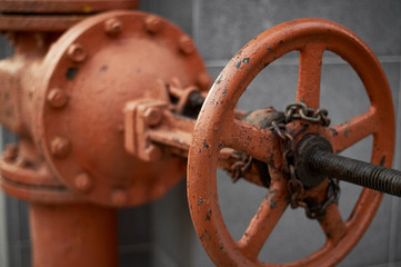 big orange iron valve old weathered flaky industrial background base